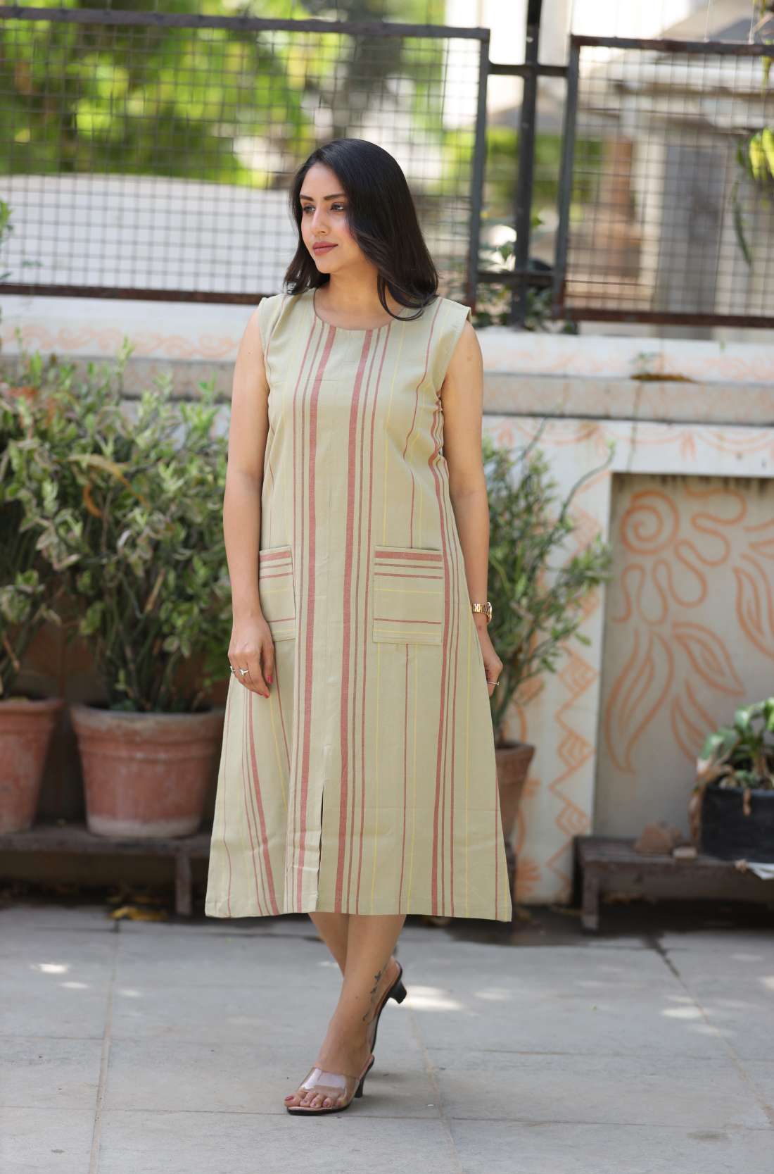 Model walking in sleeveless beige striped A-line kurti