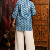 Back view of women's powder blue short kurti made from pure cotton featuring all-over hand block floral print, relaxed fit and hip-length design.