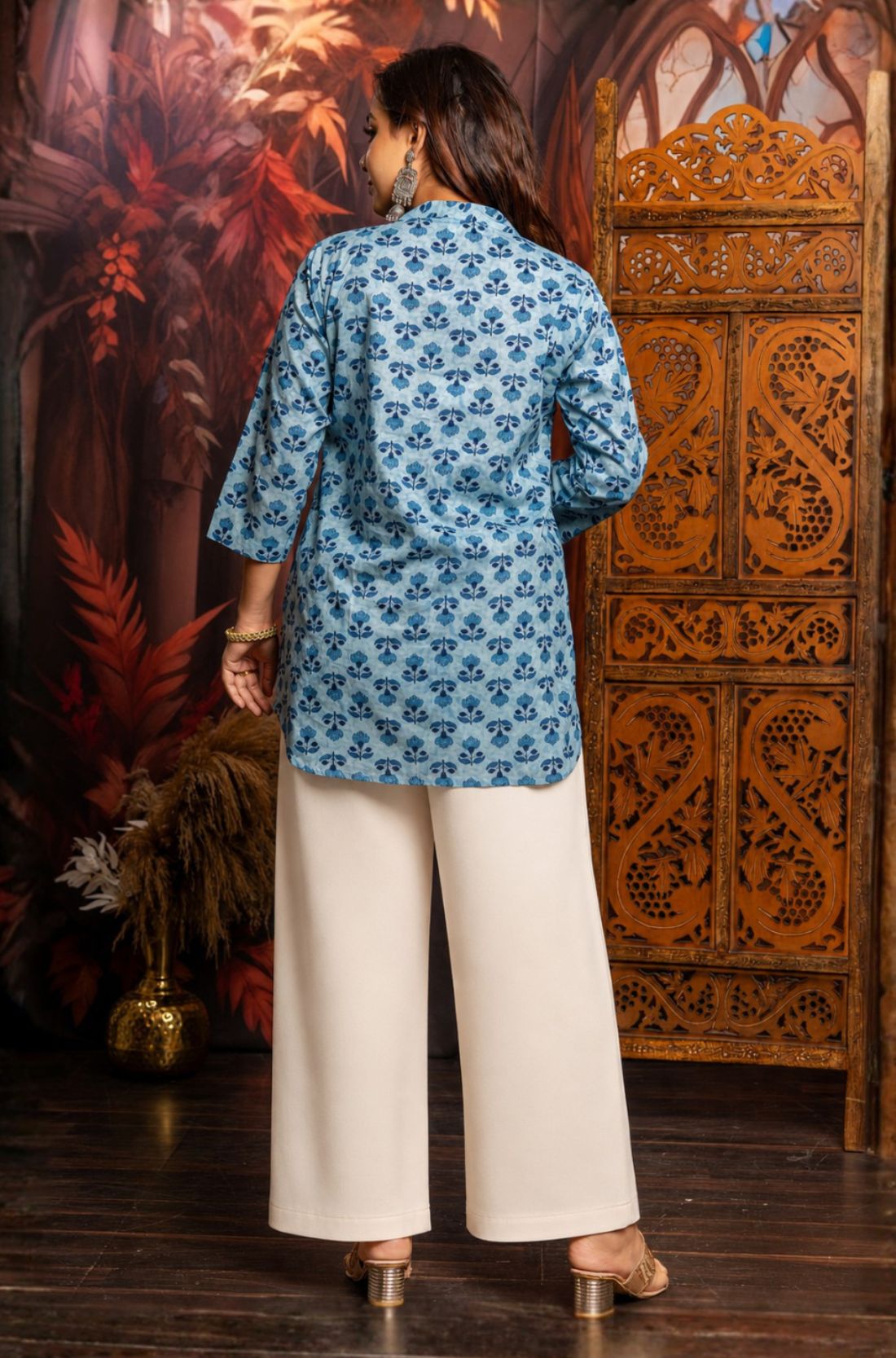 Back view of women's powder blue short kurti made from pure cotton featuring all-over hand block floral print, relaxed fit and hip-length design.