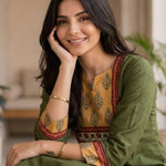 Close-up of the round neckline and contrast mustard, red, and white printed patch yoke with hand block print detailing and embroidered sleeve borders on a dark green cotton kurti.