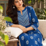 Sitting pose of the round neckline with contrast diagonal striped yoke, red piping, and white floral hand block print detailing on an indigo pure cotton kurta