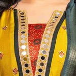 Detailed view of the mustard yellow Vichitra silk kurta neckline showcasing golden mirror work, a contrast Bandhani-print godet, dark green edging, and intricate embroidered floral motifs.