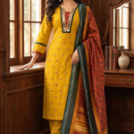 Model wearing a mustard yellow Vichitra silk kurta set featuring a mirror-work V-neckline, contrast Bandhani-print panel, sequin and thread embroidery, straight pants, and a printed Chanderi silk dupatta.