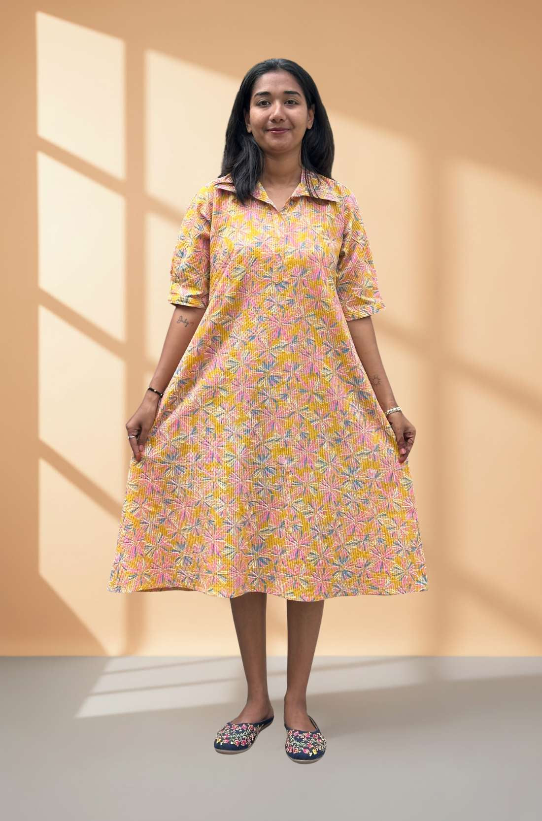 Orange dress style kurti showing flare of hemline