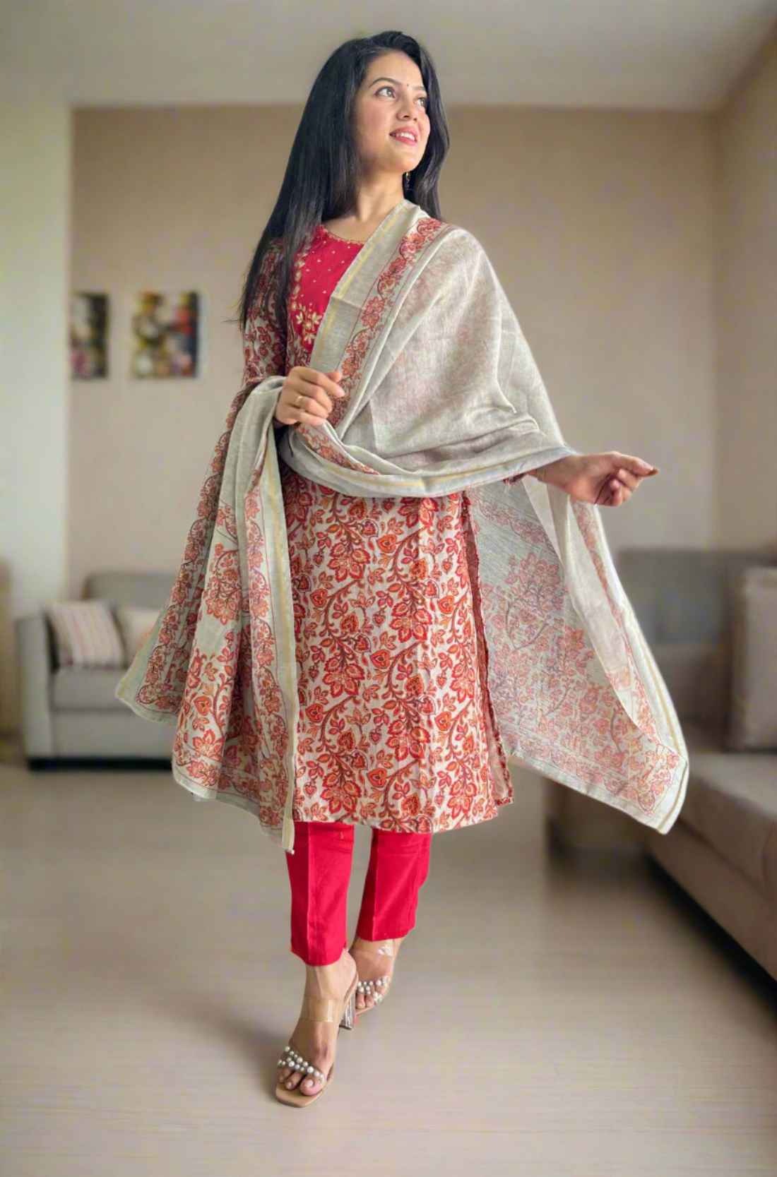 Woman holding dupatta wearing red pashmina kurta set.