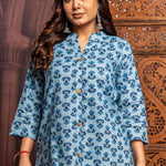 Close-up front view of powder blue short kurti in pure cotton featuring traditional hand block floral print, mandarin notch neck, wooden buttons and comfortable everyday fit.