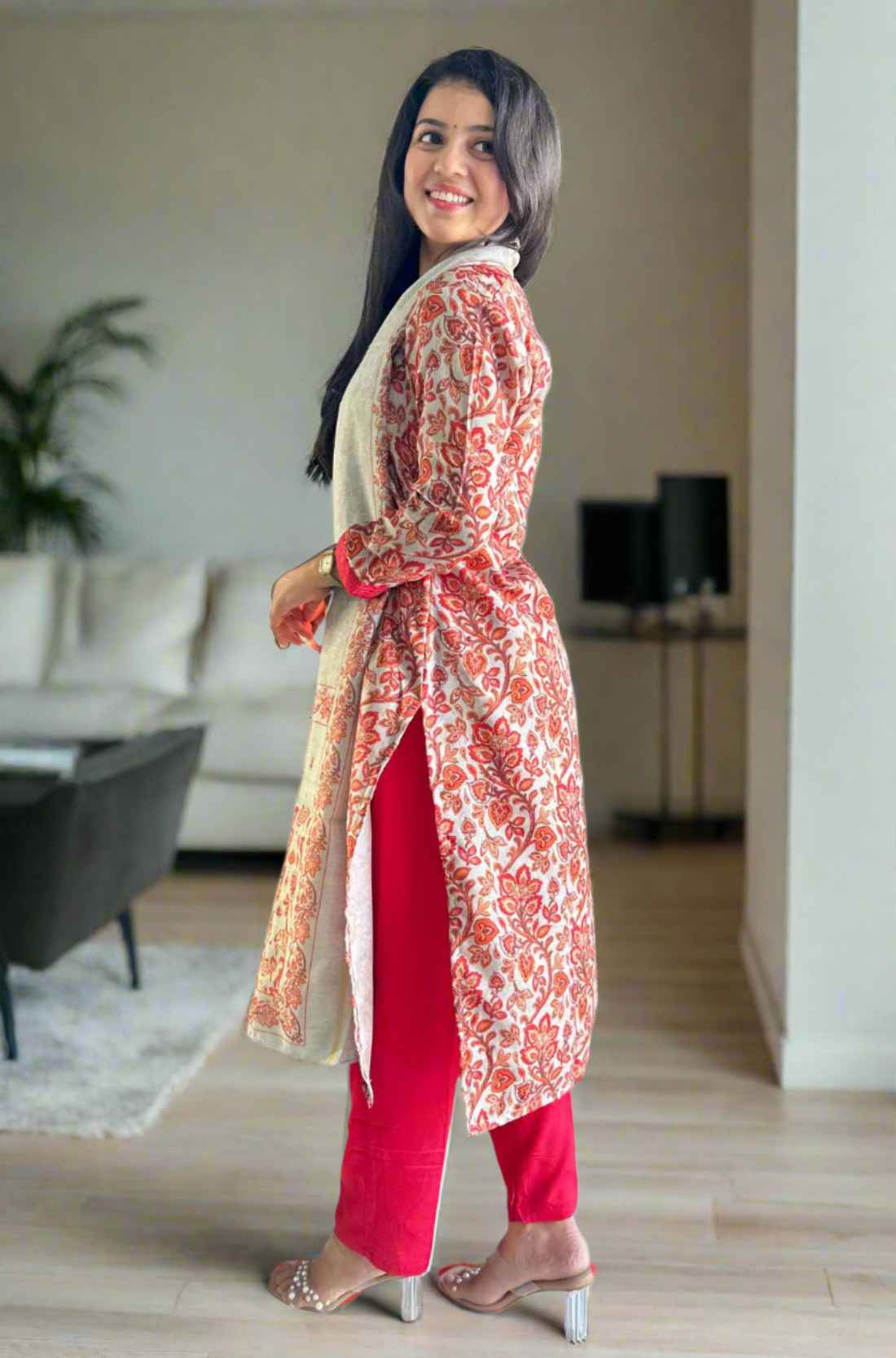 Side pose in red Pashmina kurta with printed circles and white dupatta.