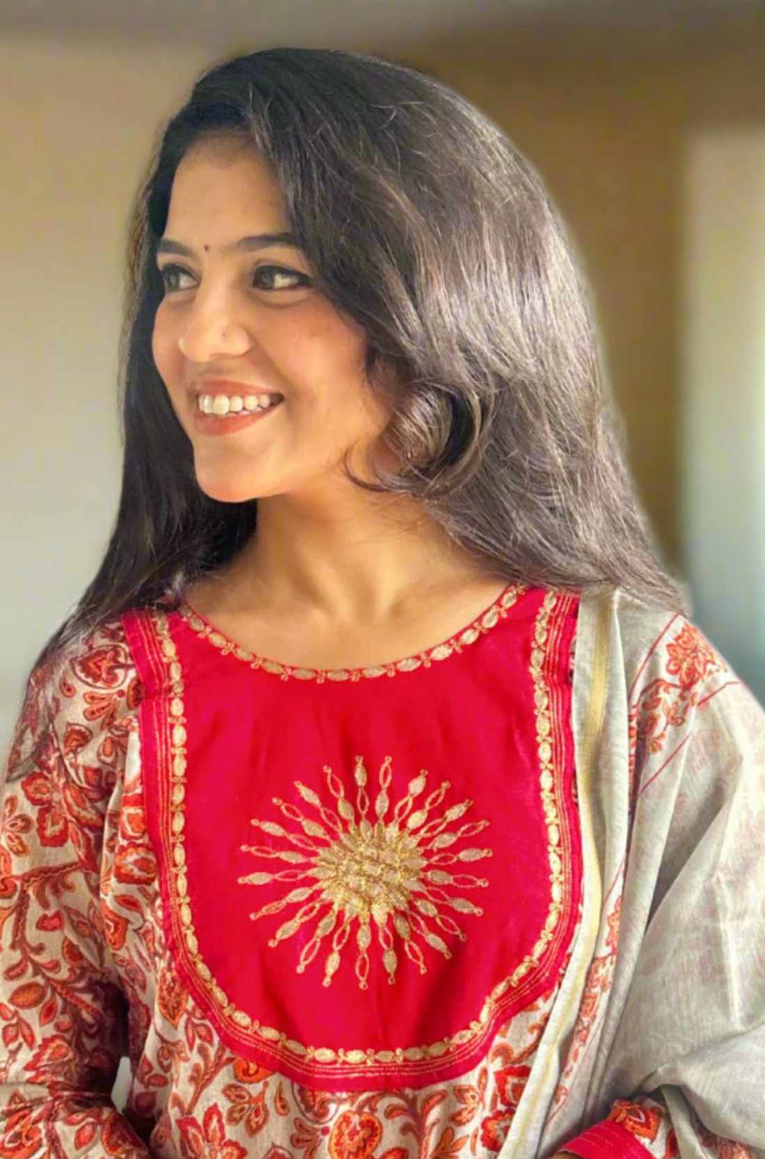 Close-up of red pashmina kurta set fabric with round motifs.