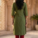 Back view of women's dark green cotton straight-fit kurti with three-quarter sleeves, calf-length design, side slits, and a clean back, paired with maroon pants.