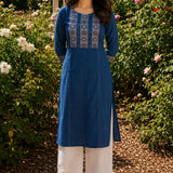 Woman wearing an indigo pure cotton hand block print kurta with mirror work yoke, round neckline and three-quarter sleeves.