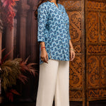 Side profile of powder blue pure cotton short kurti showcasing hand block printed floral motifs, relaxed silhouette, 3/4 sleeves and curved hem for casual ethnic wear.