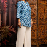 Side profile of powder blue pure cotton short kurti showcasing hand block printed floral motifs, relaxed silhouette, 3/4 sleeves and curved hem for casual ethnic wear.
