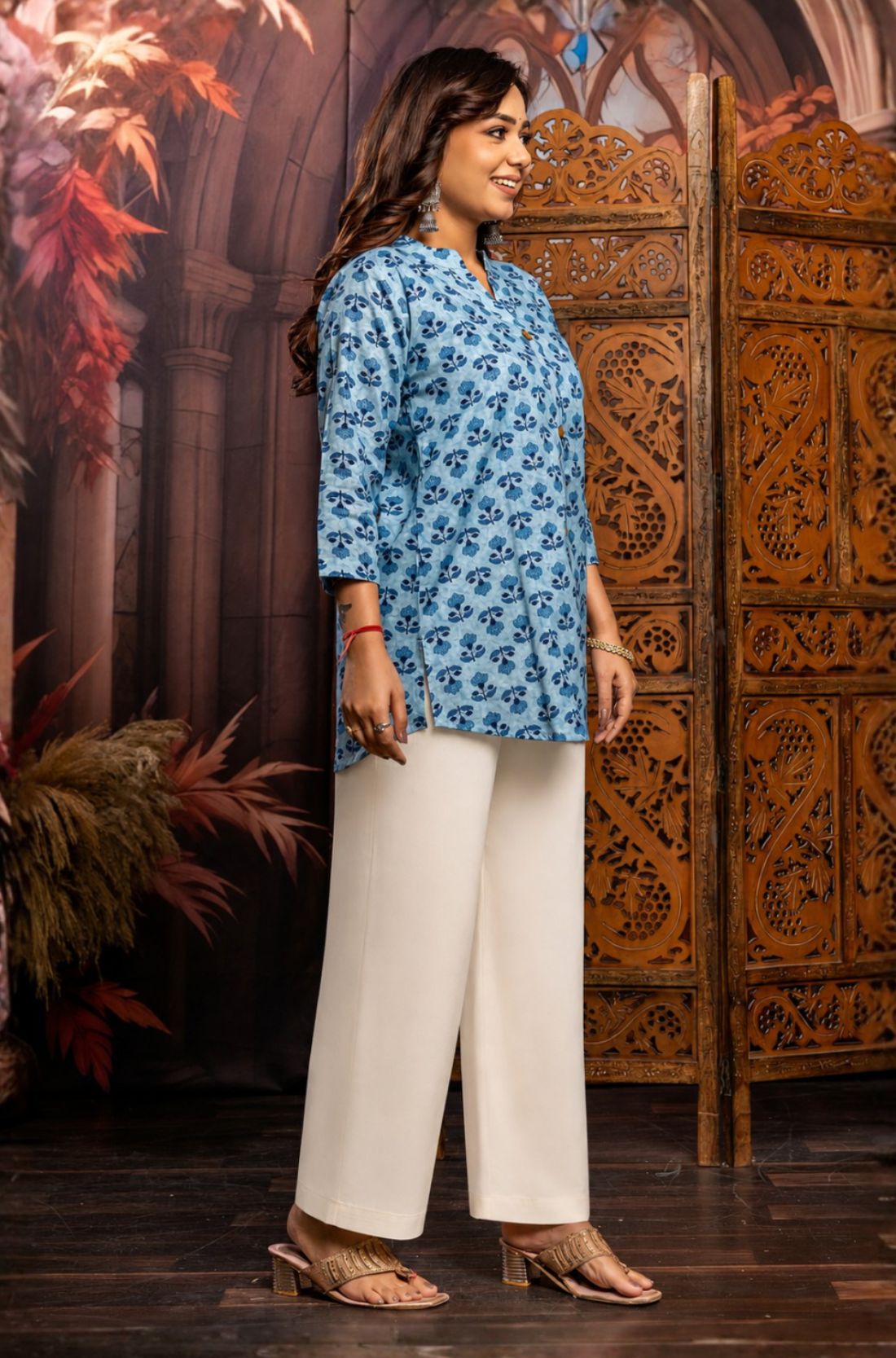 Side profile of powder blue pure cotton short kurti showcasing hand block printed floral motifs, relaxed silhouette, 3/4 sleeves and curved hem for casual ethnic wear.