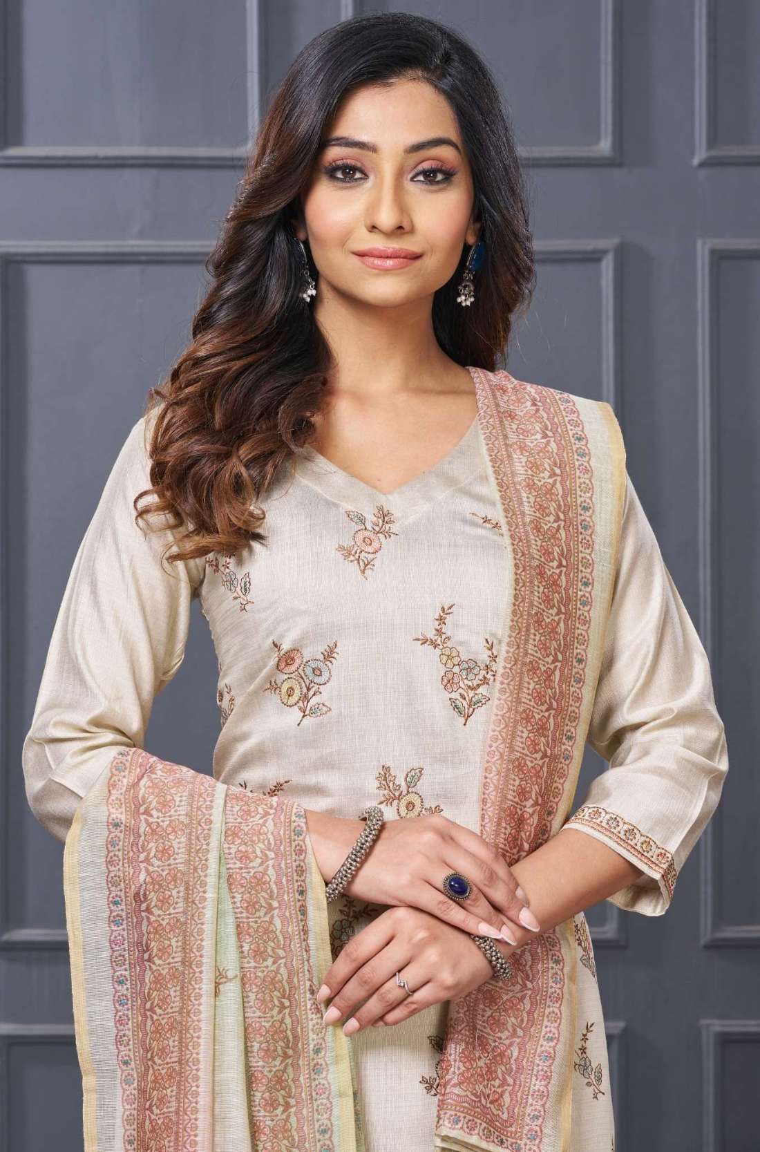 Front full length view of a model in a sophisticated beige silk 3 piece kurta set showcasing detailed embroidered scalloped edges and straight trousers
