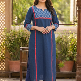 Full length front view of a woman posing gracefully in a blue ethnic wear set with floral print details.
