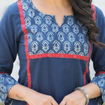 Close-up of a blue cotton kurta featuring a floral printed yoke with striking red border detailing.