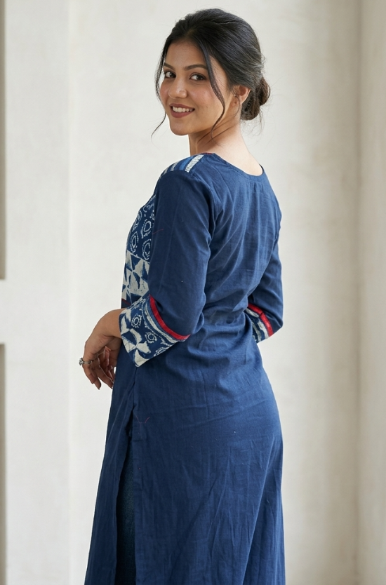 Back view of a woman looking over her shoulder, showcasing the side fit and sleeve prints of a dark blue cotton kurti.