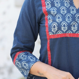 Detail shot showcasing the matching floral block print on the sleeve cuffs and neckline of a blue kurti.