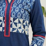 Detailed view of the white geometric block print and red stitching details on the yoke and sleeves of a blue kurti.