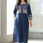 Woman walking confidently wearing a practical blue straight kurti with side pockets, paired with denim jeans and white sandals.