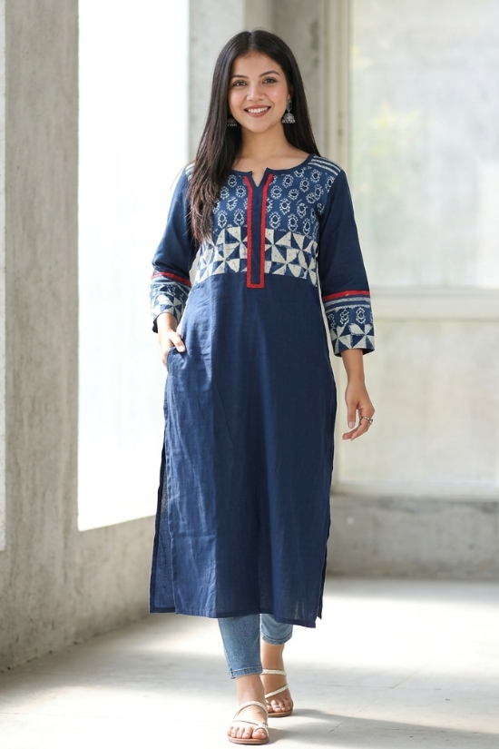 Woman walking confidently wearing a practical blue straight kurti with side pockets, paired with denim jeans and white sandals.