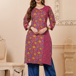 Front full length view of a model wearing a bright pink cotton floral print kurta set with matching pocketed straight pants and a coordinating printed dupatta