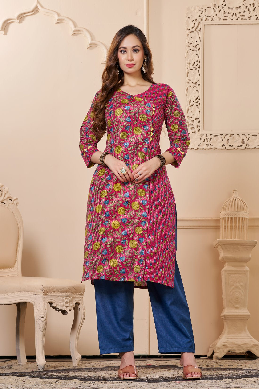 Front full length view of a model wearing a bright pink cotton floral print kurta set with matching pocketed straight pants and a coordinating printed dupatta