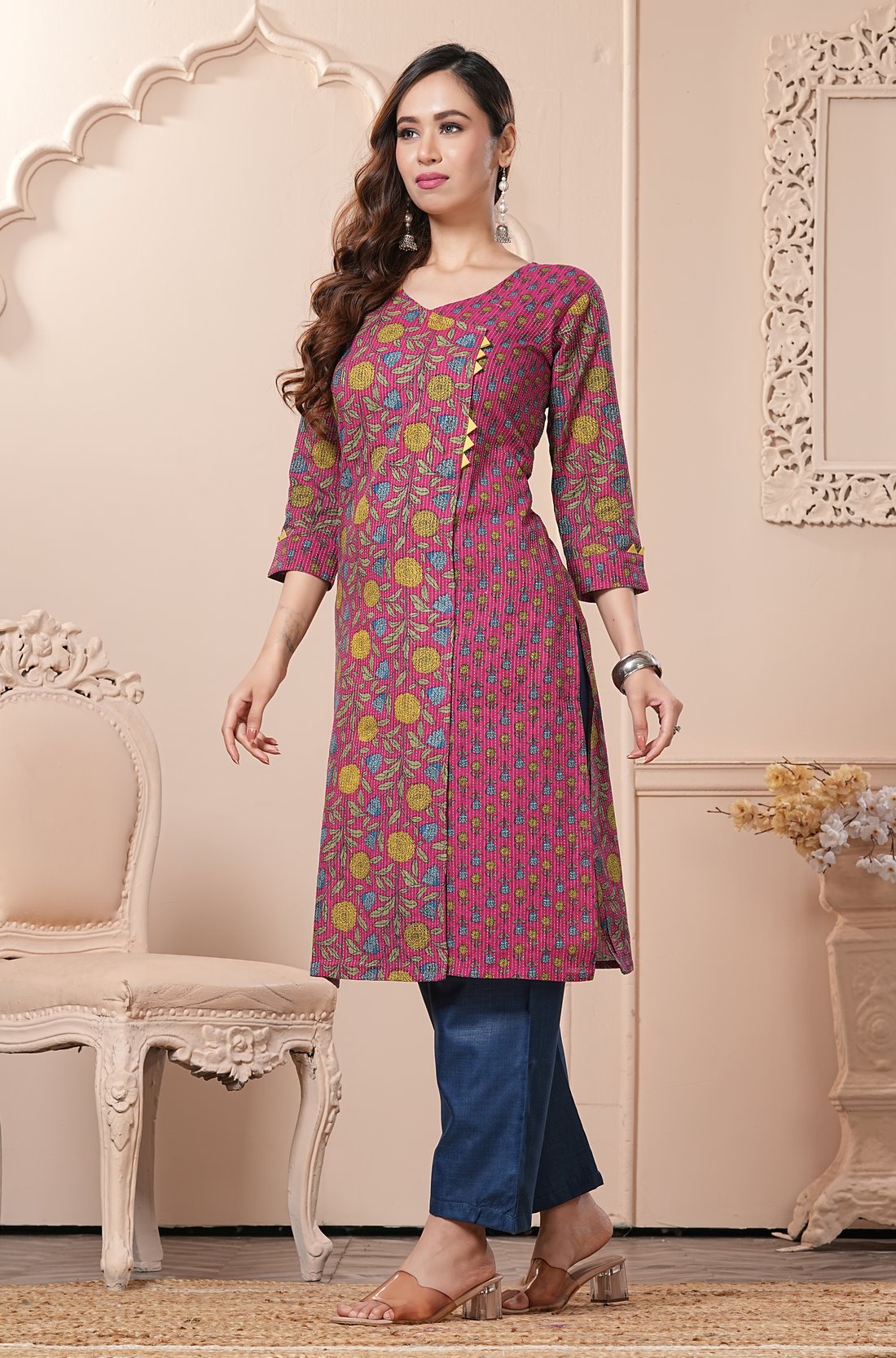 Side profile view of a model in a bright pink floral printed cotton ethnic suit showcasing the clean straight-cut fall and matching dupatta drape
