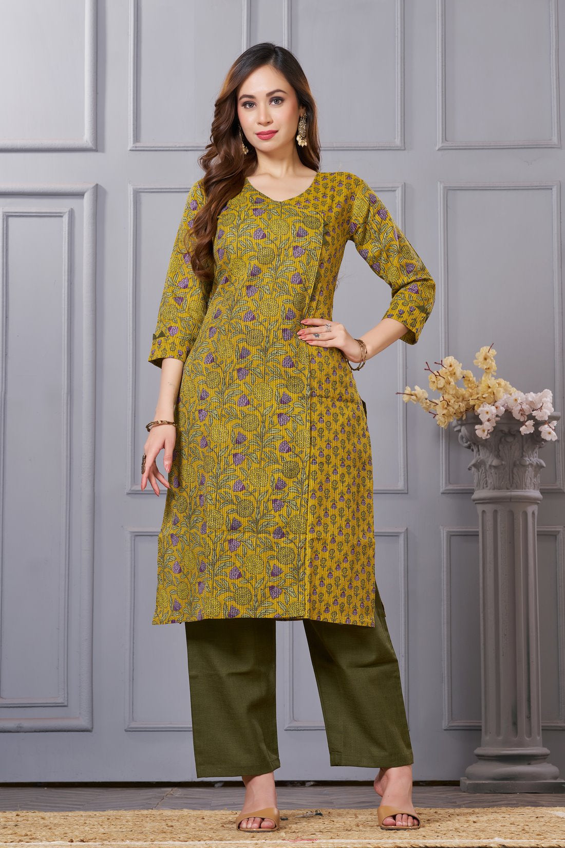 Front full length view of a model wearing a sage green cotton floral print kurta set with matching pocketed straight pants and a coordinating printed dupatta