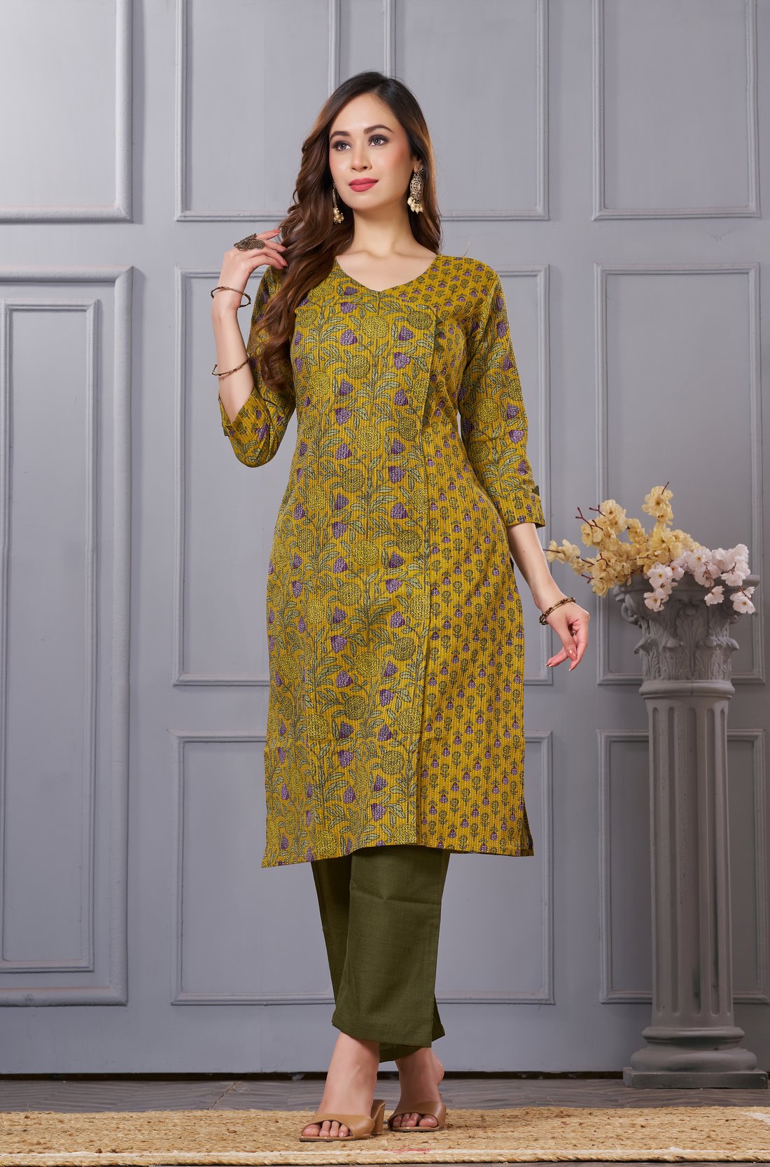 Side profile view of a model in a sage green floral printed cotton ethnic suit showcasing the regular fit and elegant side slit profile