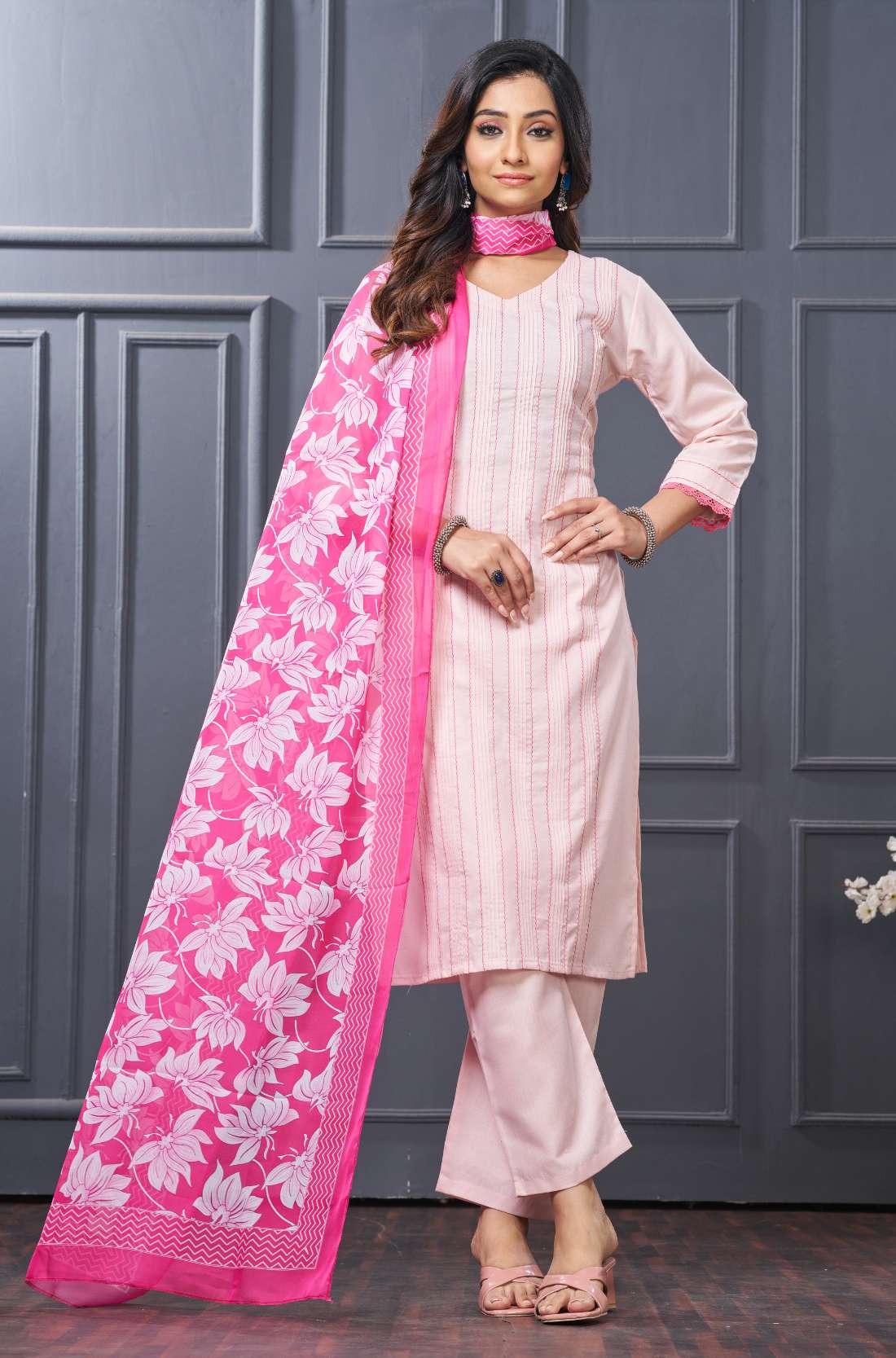 Side profile view of a model in a pink cotton ethnic suit set displaying the straight-cut pants silhouette and the beautiful pattern of the draped matching dupatta