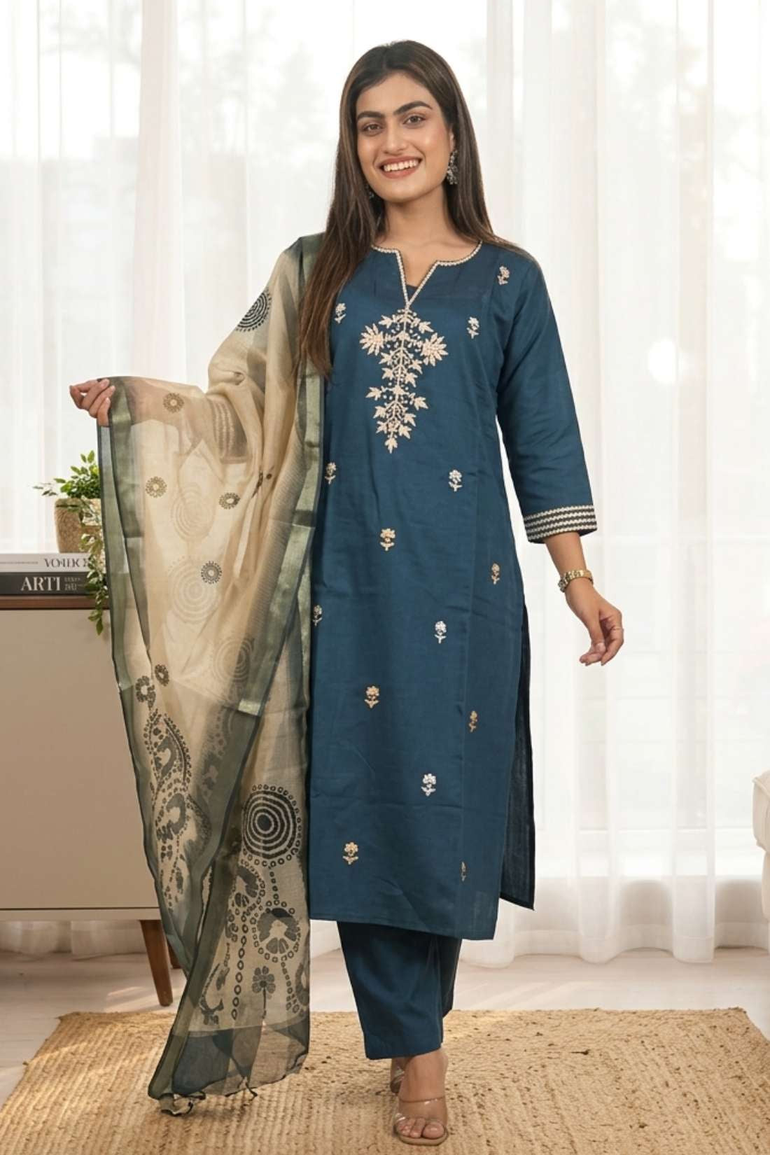 Front full length view of a model in a dark blue silk kurta set with multicolor aari embroidery and an orange chanderi dupatta