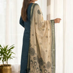 Side profile view of a model in a dark blue silk ethnic suit set with matching pants and a draped orange chanderi dupatta