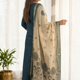 Side profile view of a model in a dark blue silk ethnic suit set with matching pants and a draped orange chanderi dupatta