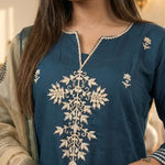 Close up shot of the intricate floral aari embroidery and button neckline details on a dark blue silk kurta