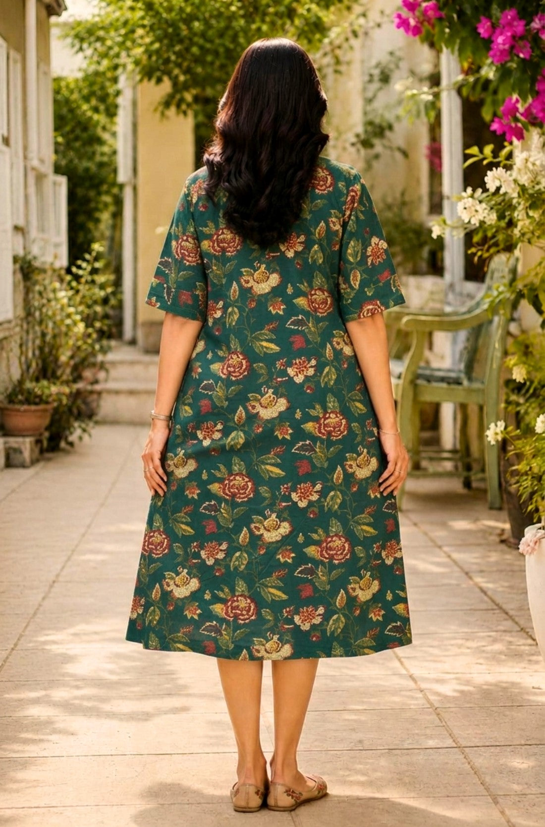 Full-length back view of the dark green cotton printed frock-style kurti, highlighting the continuous floral pattern distribution and the relaxed A-line flare.