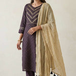 Left side angled view of a woman posing in a premium dark purple pure crepe hand embroidered kurta set displaying the complete festive outfit