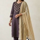 Left side angled view of a woman posing in a premium dark purple pure crepe hand embroidered kurta set displaying the complete festive outfit