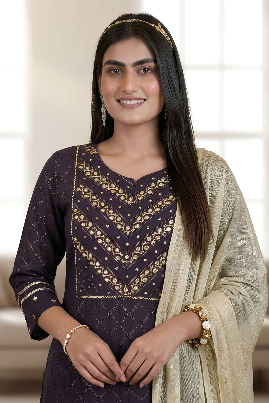 Detailed close up view of a premium dark purple crepe suit showcasing exquisite golden and metallic hand embroidery along the split crew neckline and front bodice.