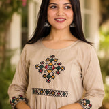 Close-up of beige A-line rayon kurta showing multicolour cross stitch embroidery on yoke and sleeves