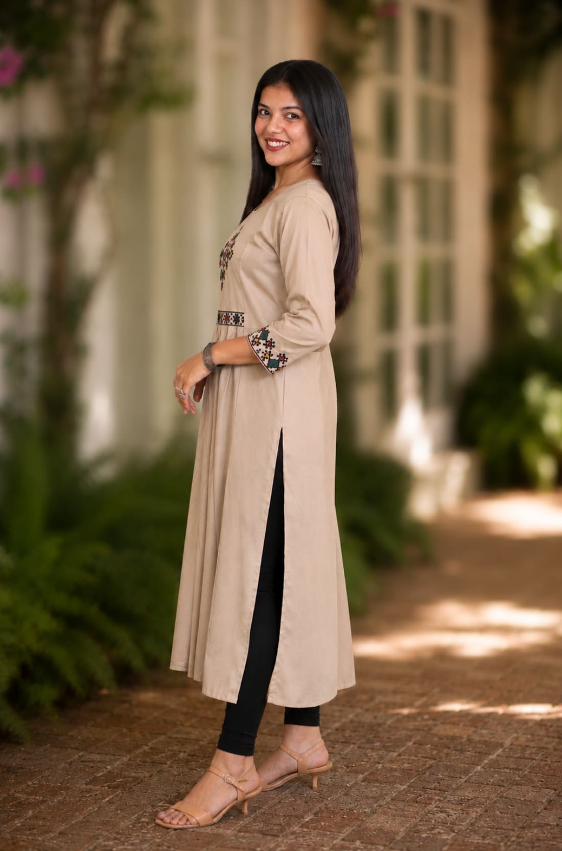 Side view of embroidered beige A-line rayon kurta with 3/4 sleeves and side slit
