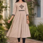 Model wearing embroidered beige A-line rayon kurta with flared hem and black leggings, walking front view