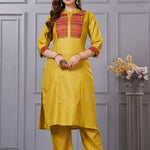 Front full length view of a model wearing an embroidered ochre yellow yoke cotton straight kurta set with pocketed pants and a printed dupatta