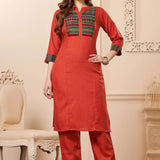 Front full length view of a model wearing an embroidered rust orange yoke cotton straight kurta set with pocketed pants and a printed dupatta