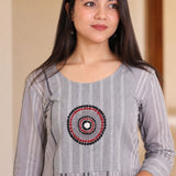 Close-up of grey A-line cotton kurta showing circular embroidery and striped cotton fabric