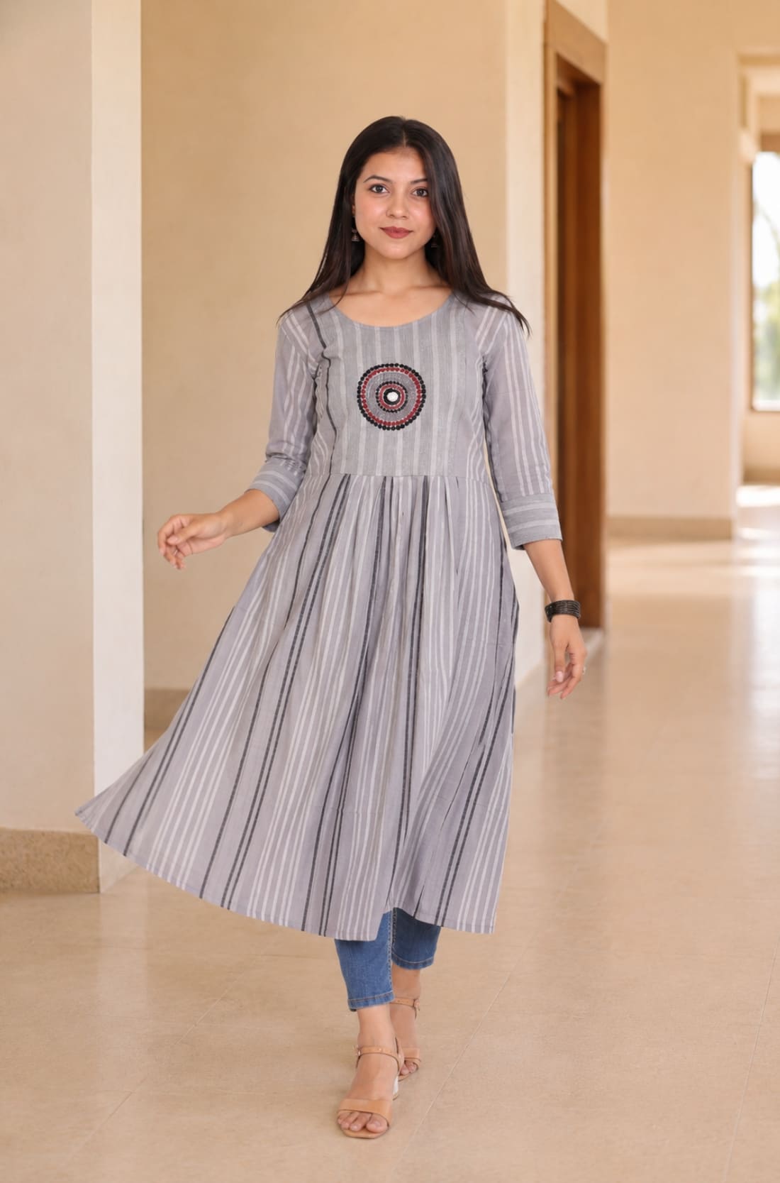 Model wearing grey A-line cotton kurta with flared hem and striped pattern, walking front view