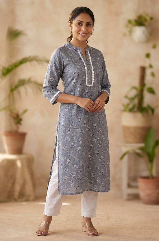 A full-length studio shot of a woman modeling a grey-blue printed straight kurta with white pants.