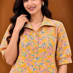 Upper-body close-up of Jaipur floral print cotton midi dress in ochre yellow with collared neckline, elbow sleeves and multicolour floral motifs.