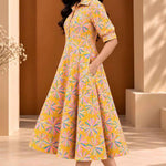 Side view of ochre yellow Jaipur floral print cotton A-line midi dress with elbow-length sleeves, flared hem and side pocket.