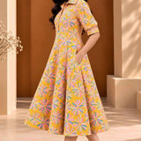 Side view of ochre yellow Jaipur floral print cotton A-line midi dress with elbow-length sleeves, flared hem and side pocket.
